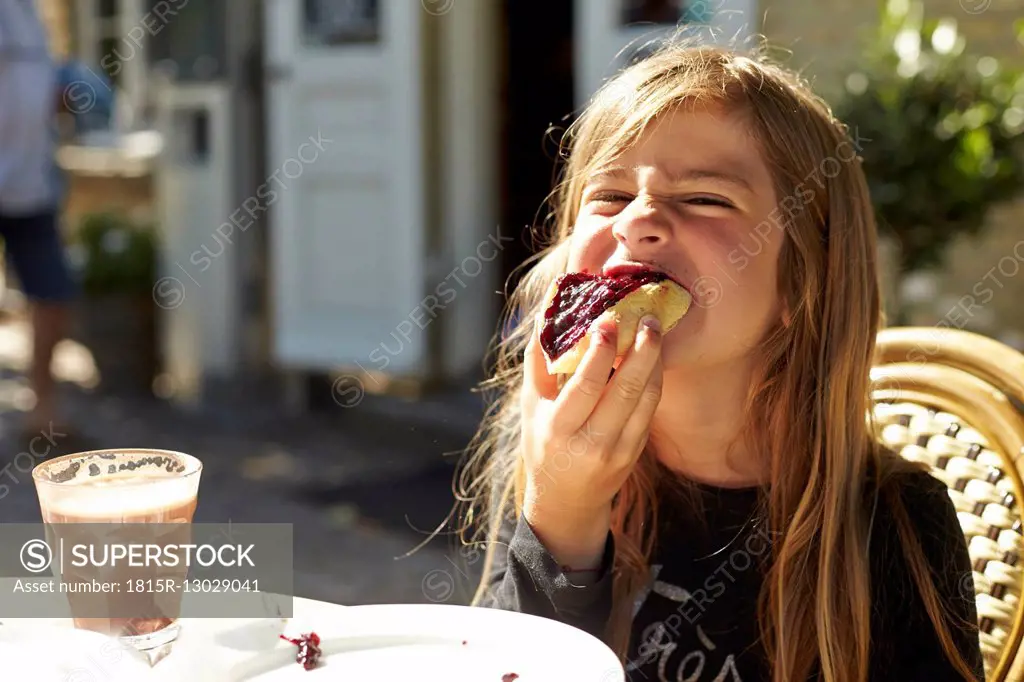 Portrait of girl eating bread with jam