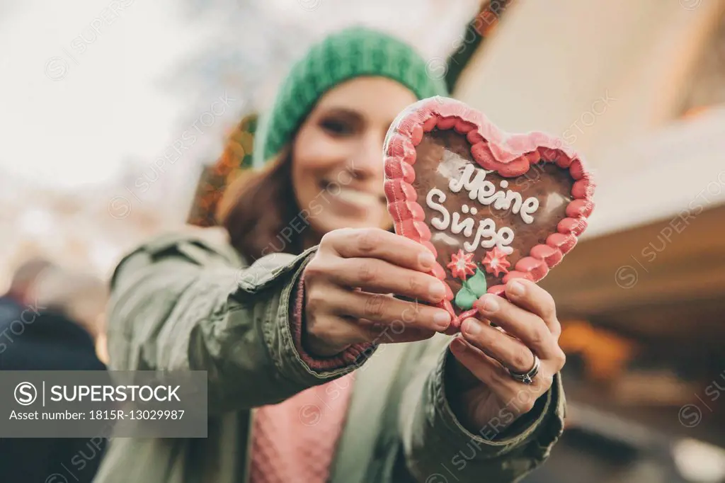 Woman holding up a gingerbread heart on the Christmas Market