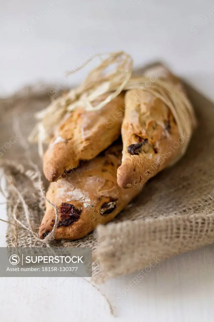 Breadsticks tied up with straw on jute sack, close up