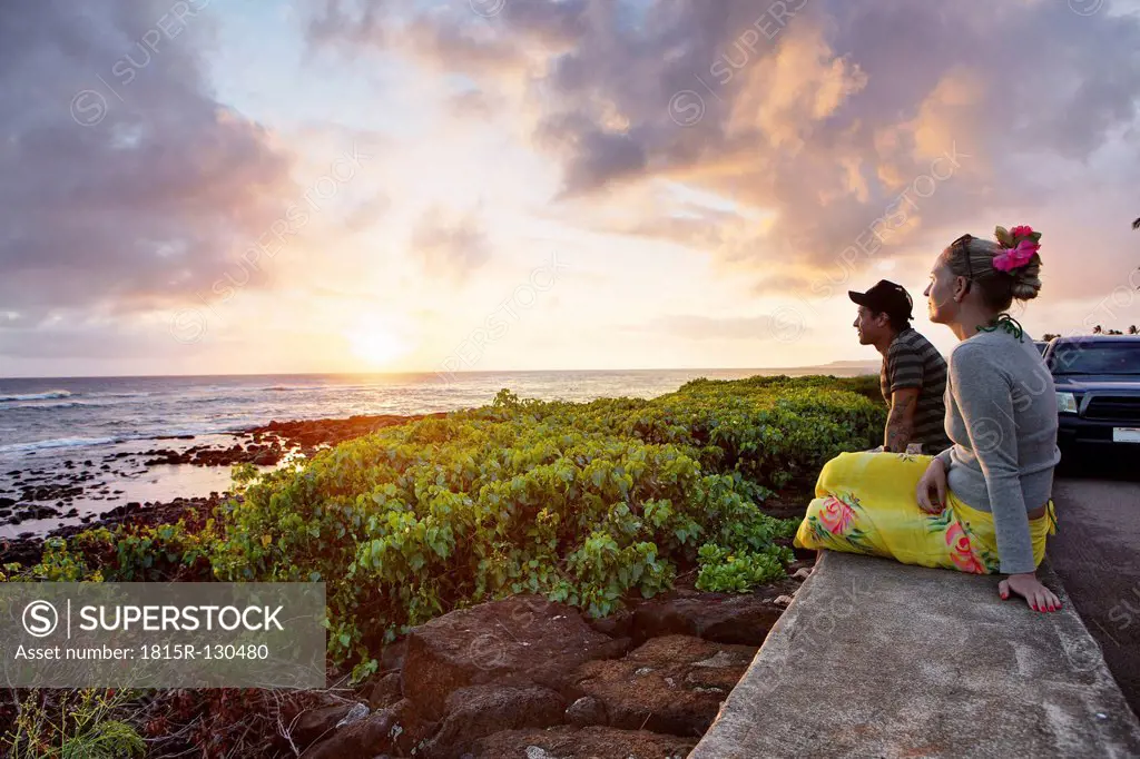 USA, Hawaii, Mid adult couple watching sundown by sea