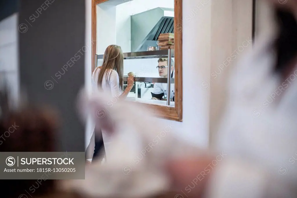 Waitress picking up food from the kitchen