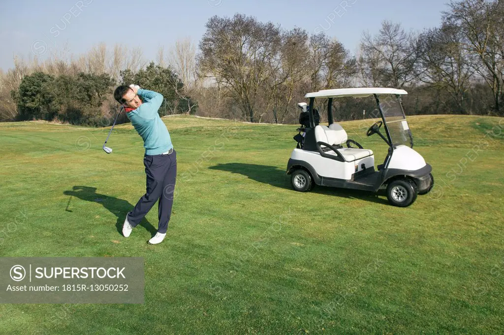 Golfer on a golf course, golf cart