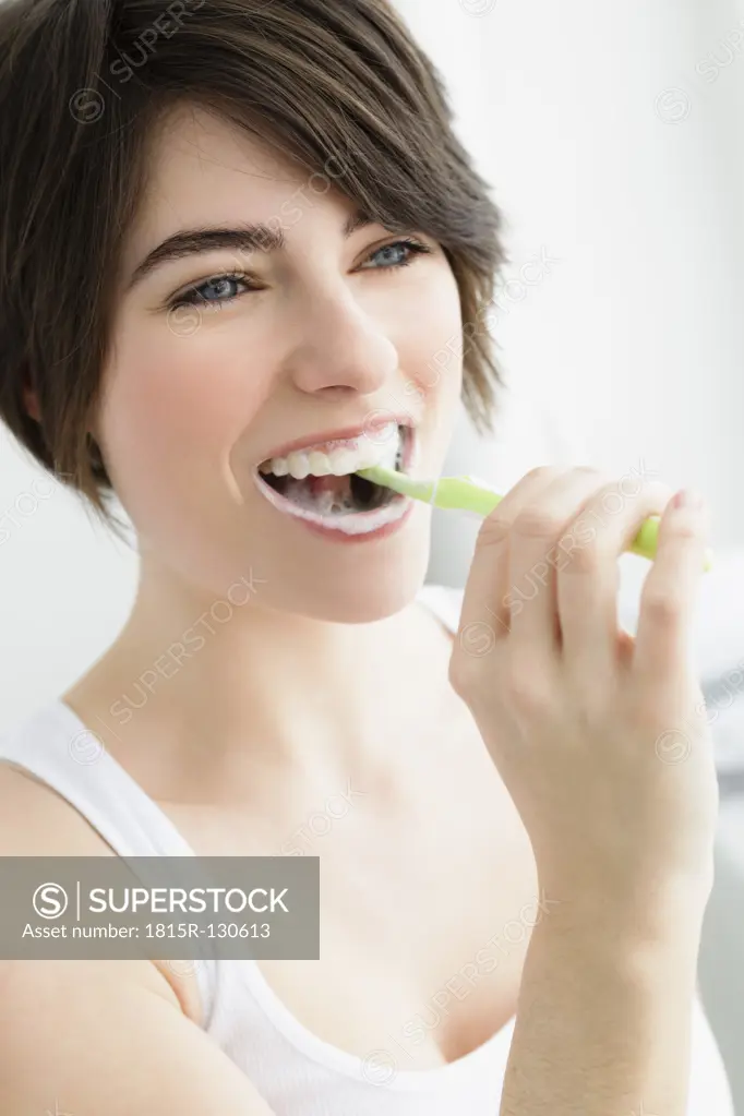Germany, Bavaria, Munich, Young woman brushing teeth, close up