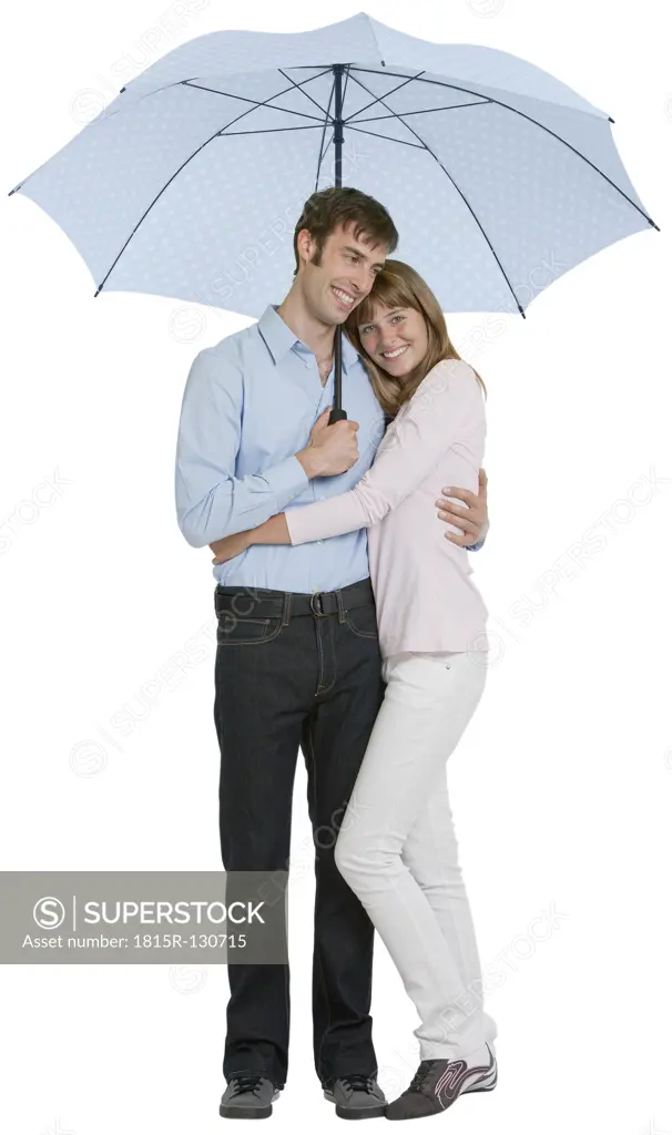 Couple embracing under umbrella, smiling