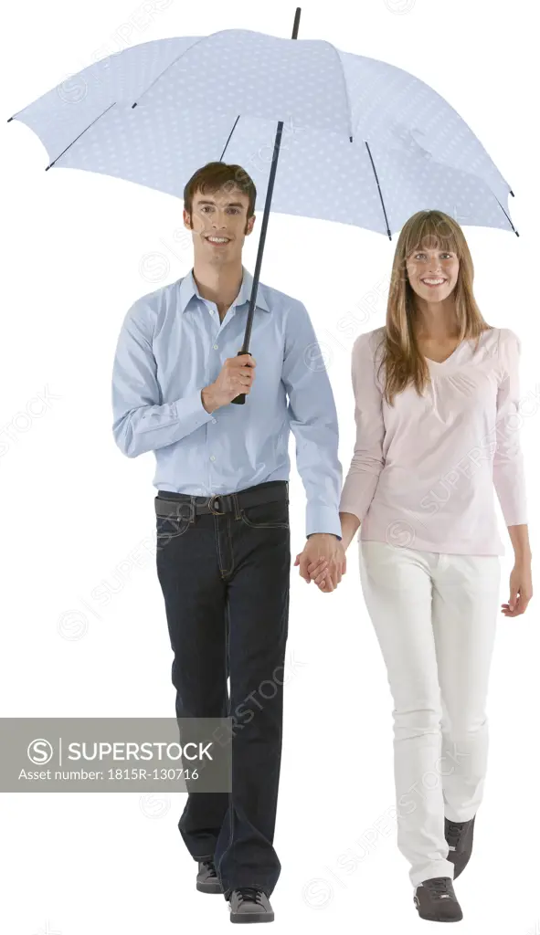 Couple walking with umbrella, smiling
