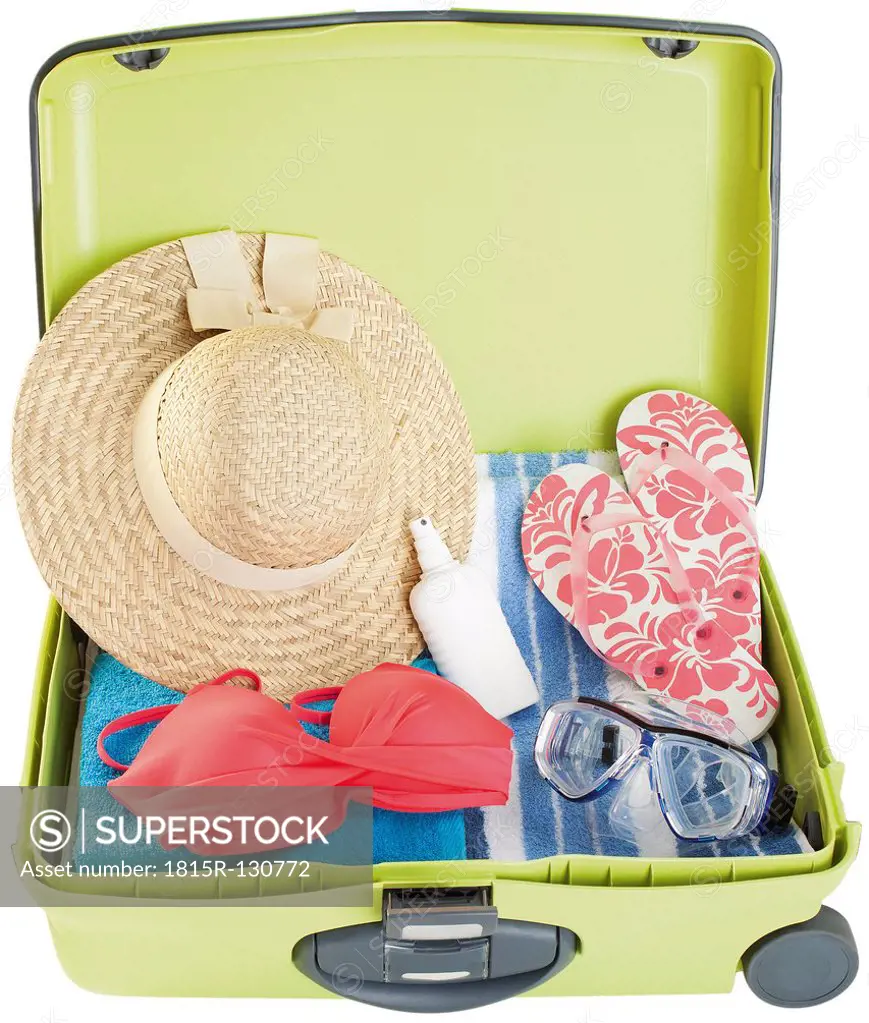 Suitcase with swimsuits on white background, close up
