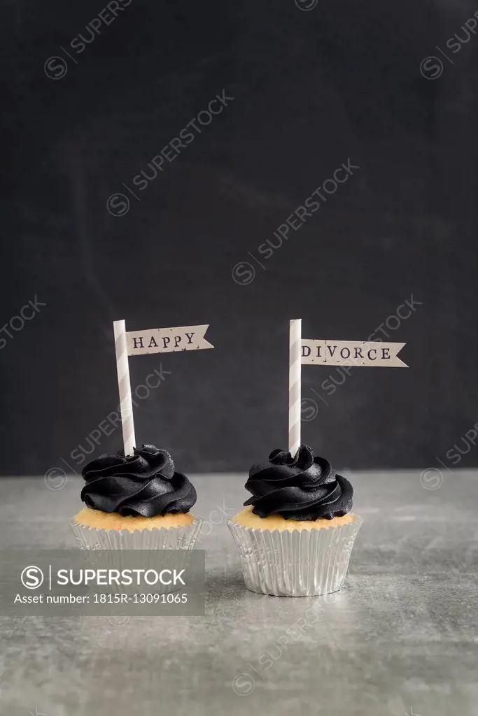 Two cup cakes with black coloured buttercream topping and pennons