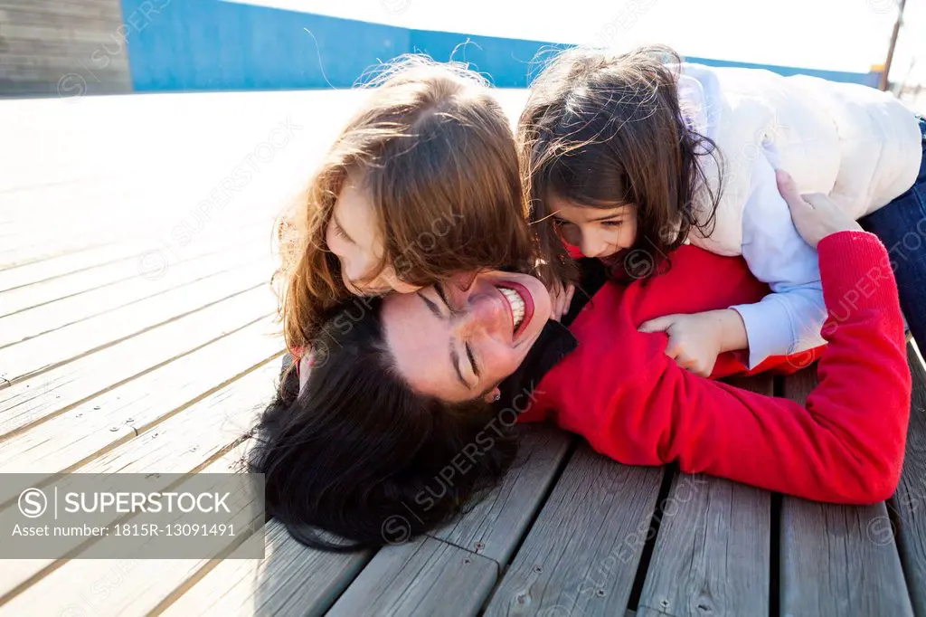 Mother and her two daughters playing on a deck