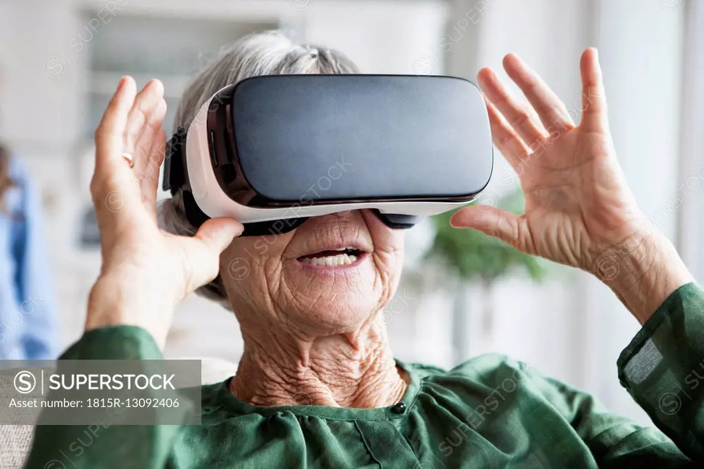 Senior woman using Virtual Reality Glasses at home