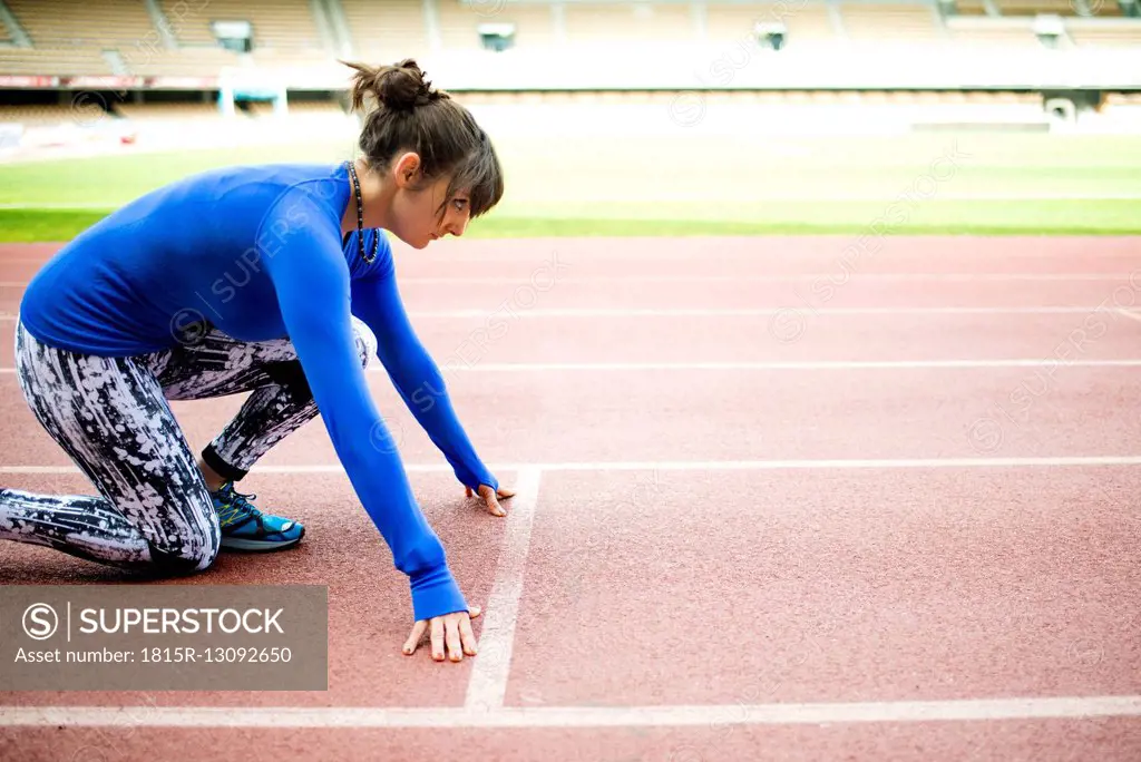Female athlete training for race in stadium