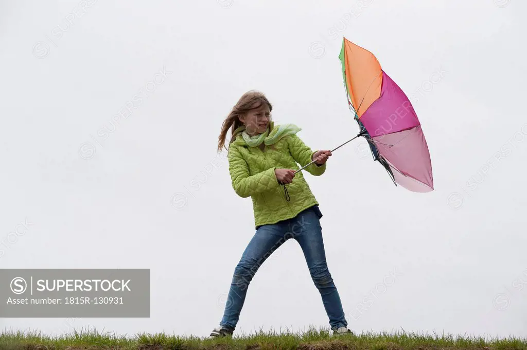 Germany, Bavaria, Starnberg, Girl fighting with rough weather