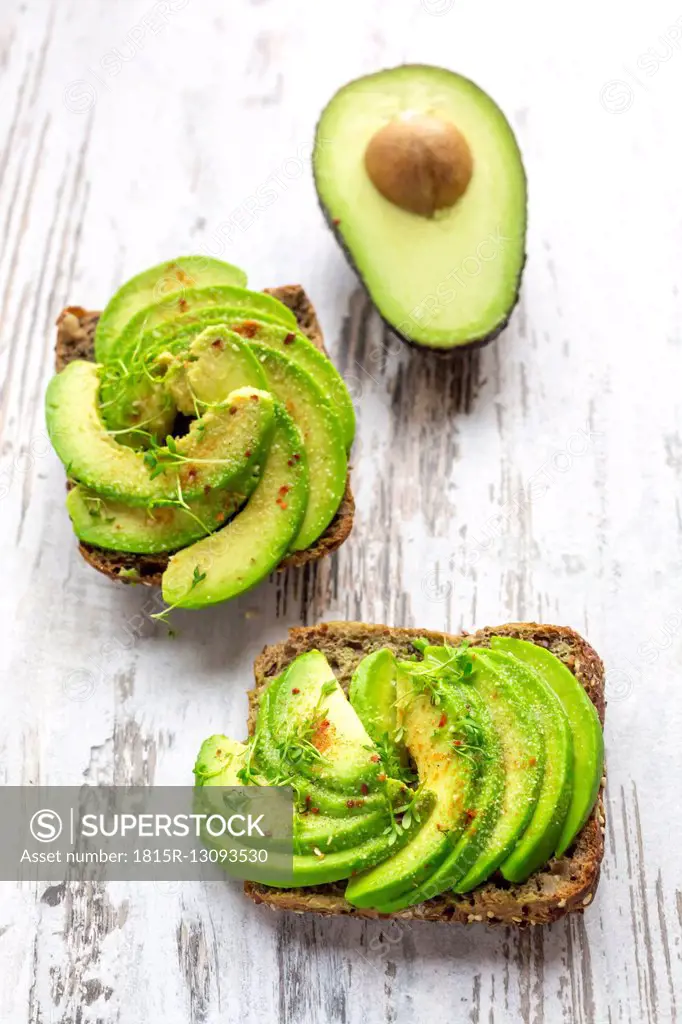 Protein bread garnished with sliced avocado, cress and chili powder