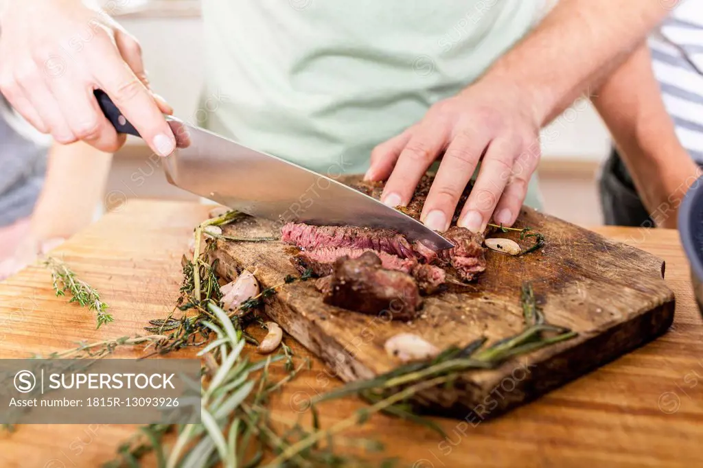 Cutting steak on chopping board