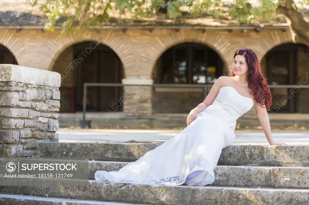 USA, Texas, Young bride in wedding dress posing at historical building