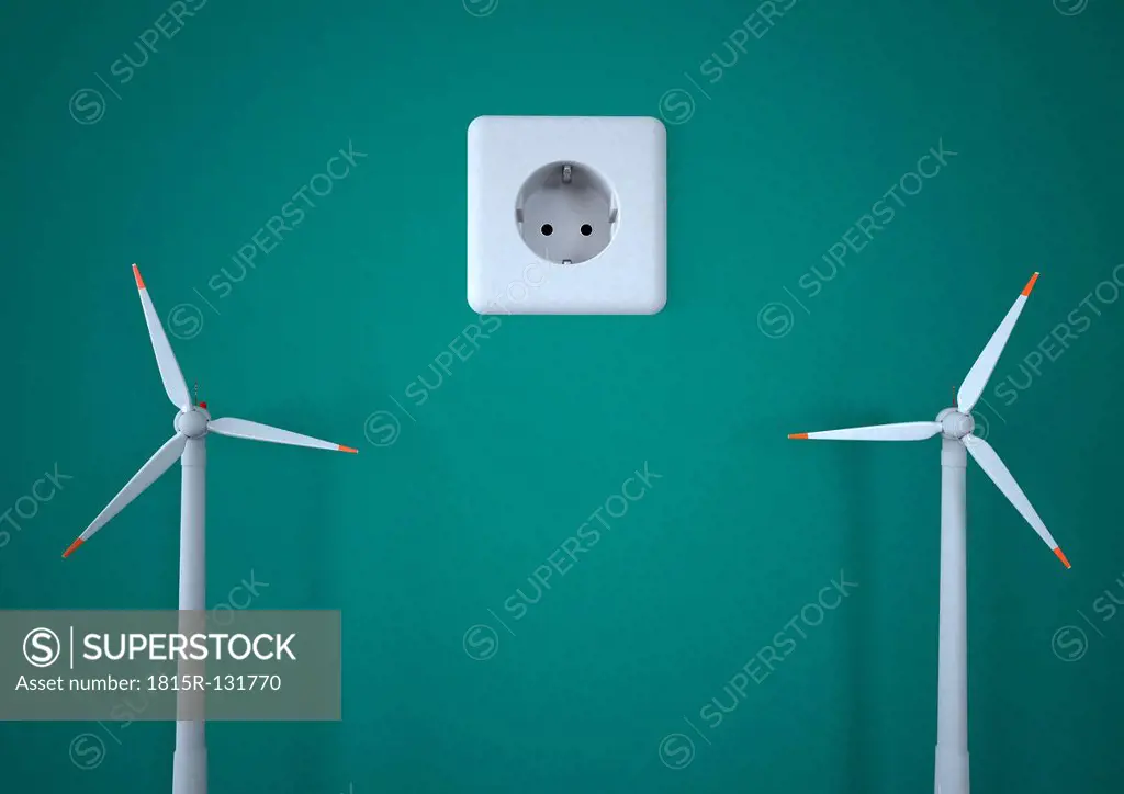 Power socket with wind turbines against green background, close up