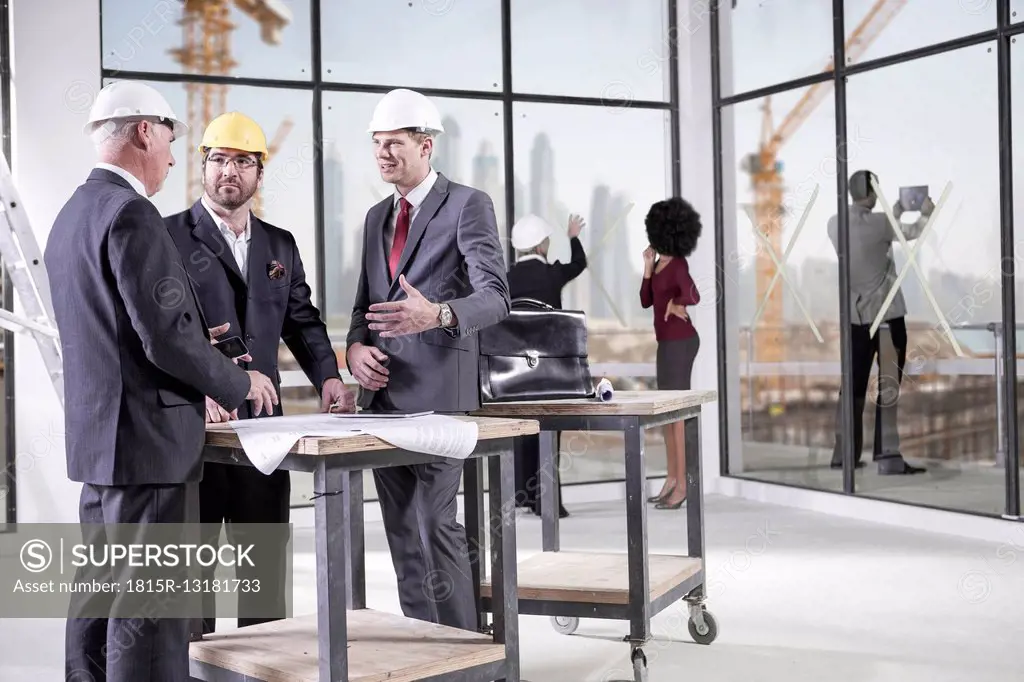Businessmen talking in office under construction