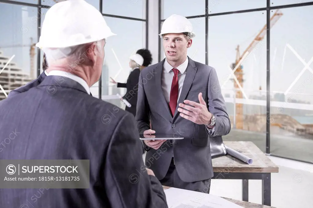 Businessmen talking in office under construction