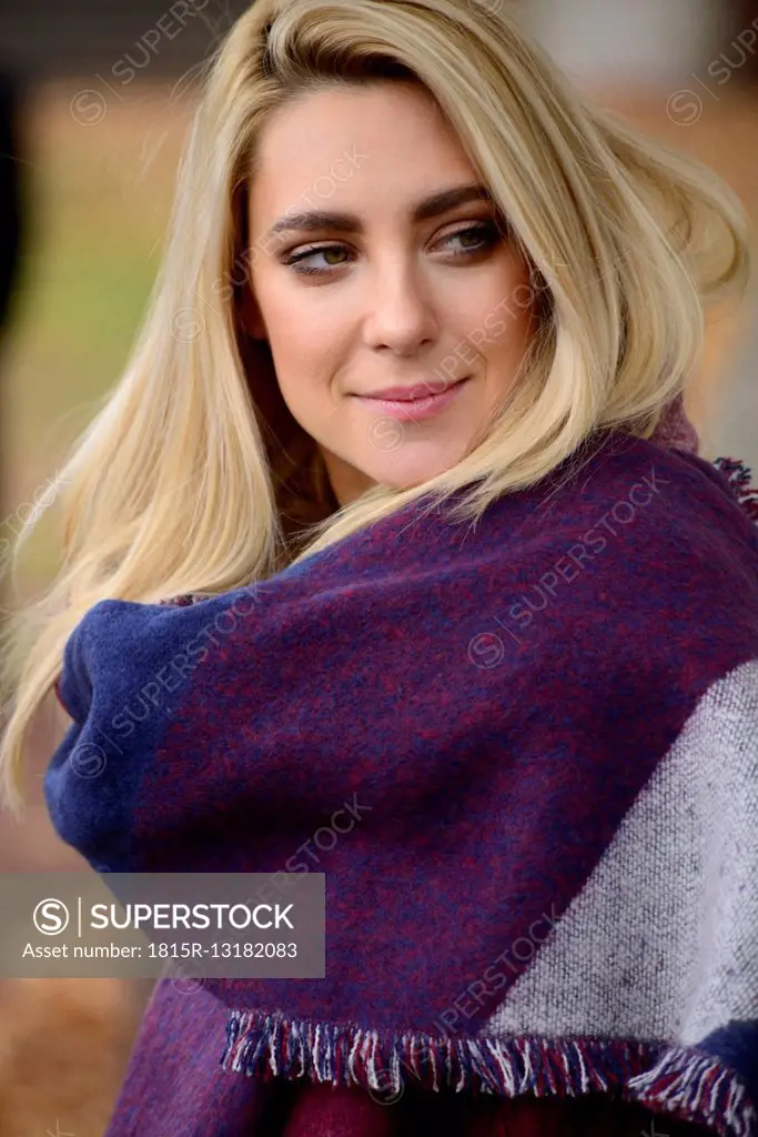 Portrait of blond young woman wearing fashionable shawl