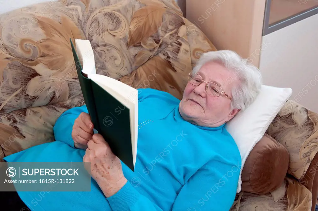 Germany, Berlin, Senior woman reading book
