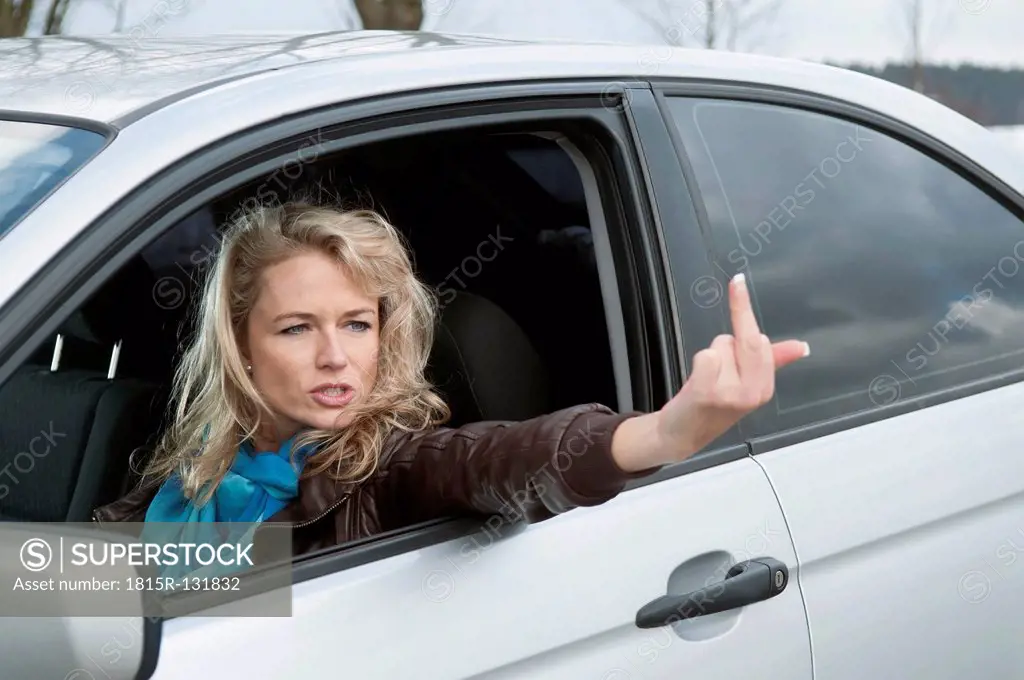 Germany, Brandenburg, Angry woman showing obscene gesture