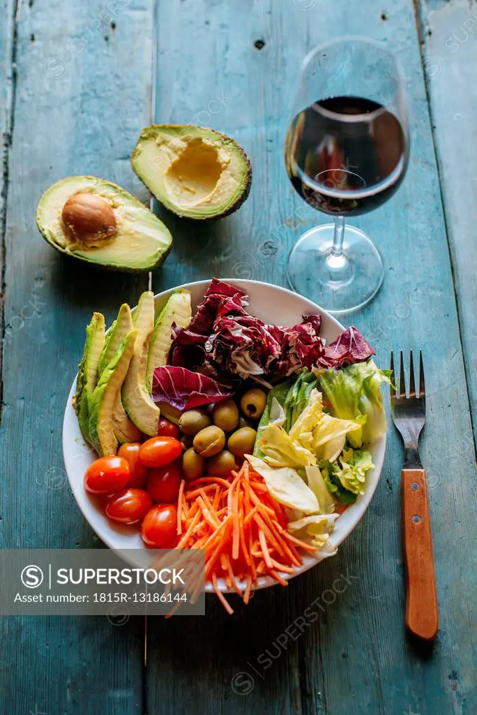 Mixed salad , sliced avocado and glass of red wine