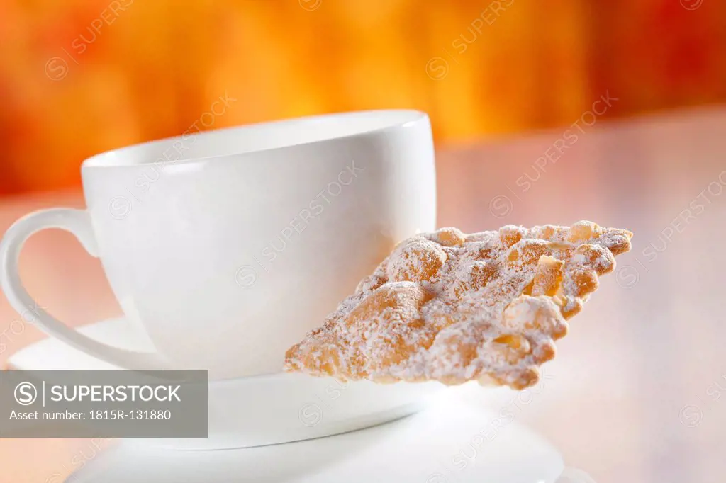 Tea cup and saucer with mutzen pastry, close up