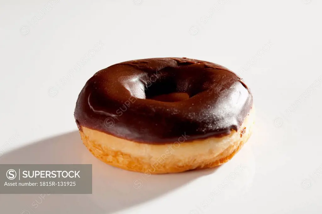 Chocolate covered donut on white background, close up