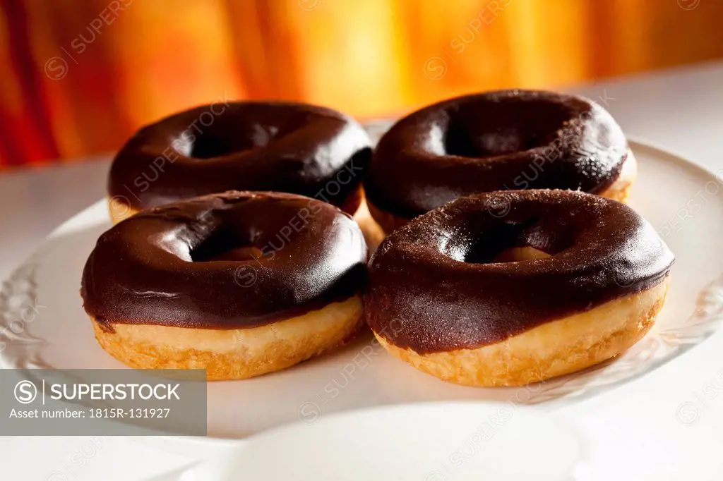 Chocolate covered donuts on plate, close up
