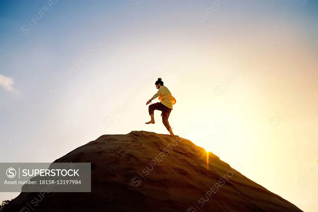 Man with bun running uphill