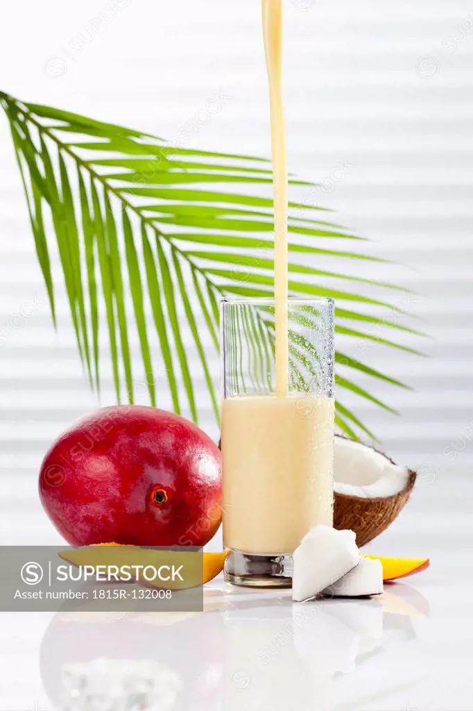 Glass of smoothie with coconut and mango, close up