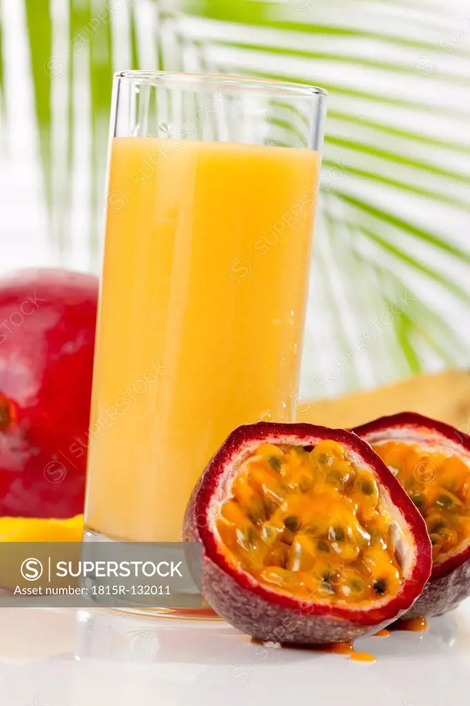 Glass of smoothie with mango, passion fruit, and banana, close up