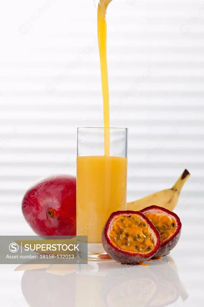 Glass of smoothie with mango, passion fruit, and banana, close up