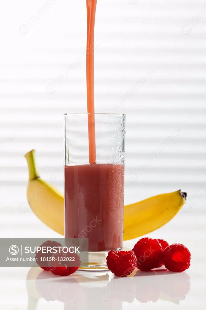 Glass of smoothie with raspberry and banana, close up