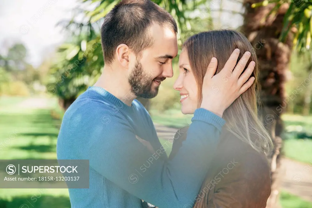 Happy couple face to face in a botanical garden