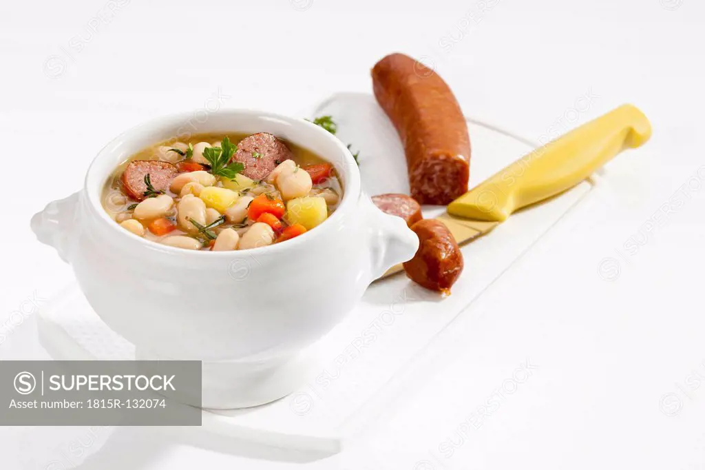 Bowl of white bean soup with smoked sausage, close up