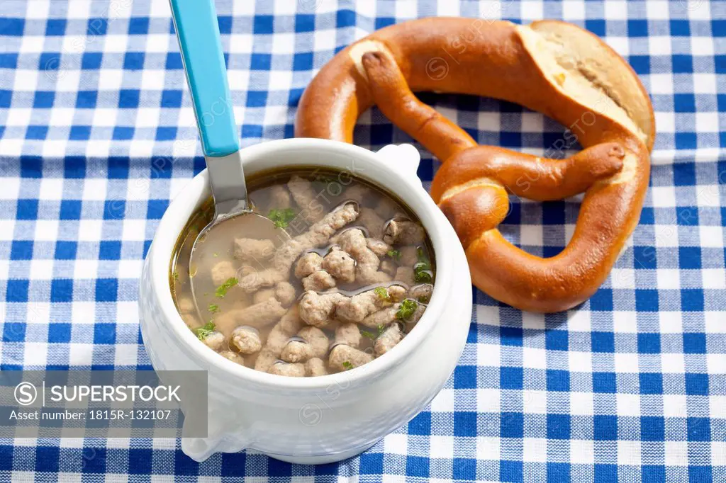 Bowl of liver spaetzle soup with pretzel, close up