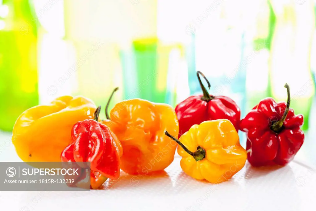 Red and yellow habaneros peppers on chopping board