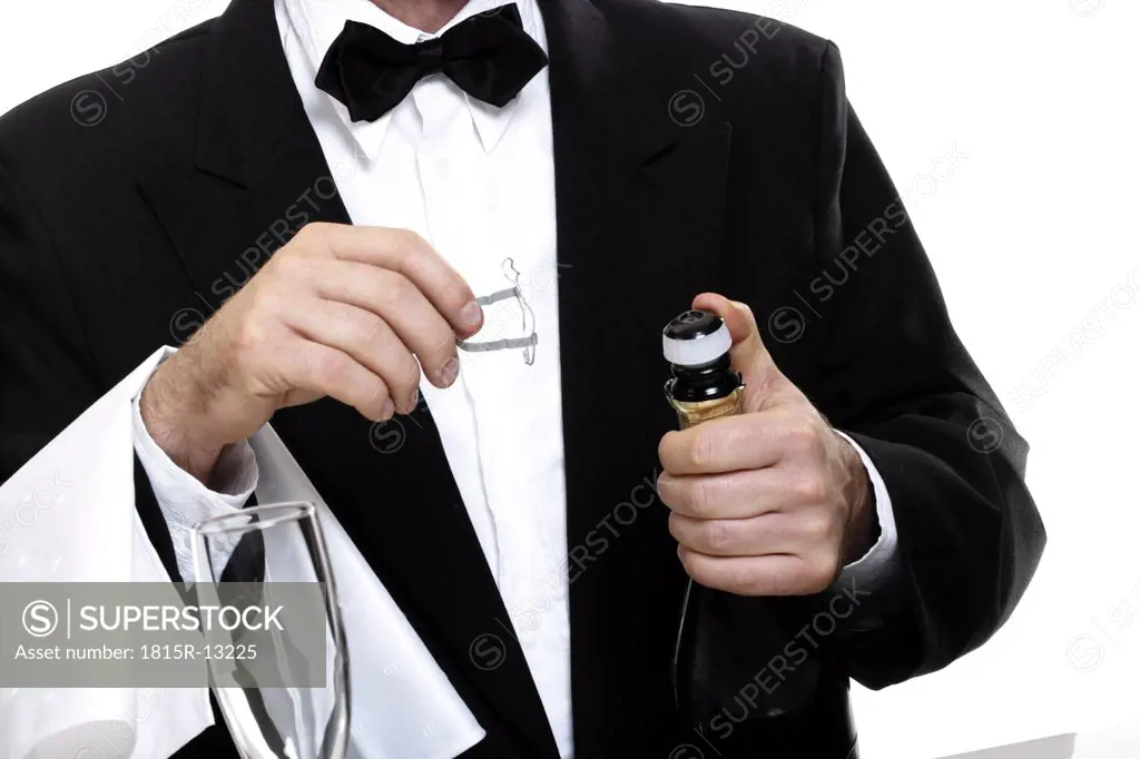 Barkeeper opening bottle of sparkling wine
