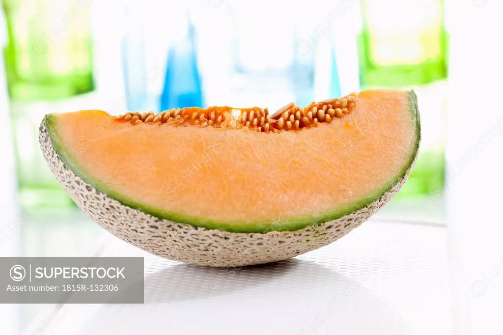 Slice of cantaloupe melon on chopping board, close up
