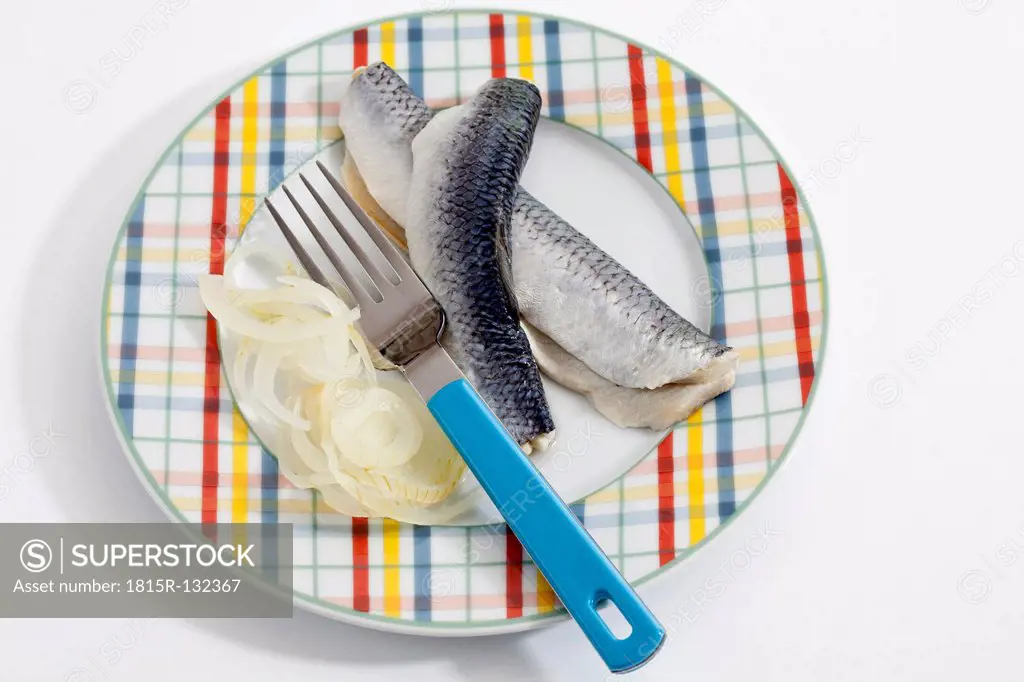 Herring with onions and vinegar on plate, close up