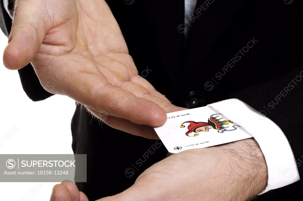 Man extracting playing card out of sleeve, close-up, mid section