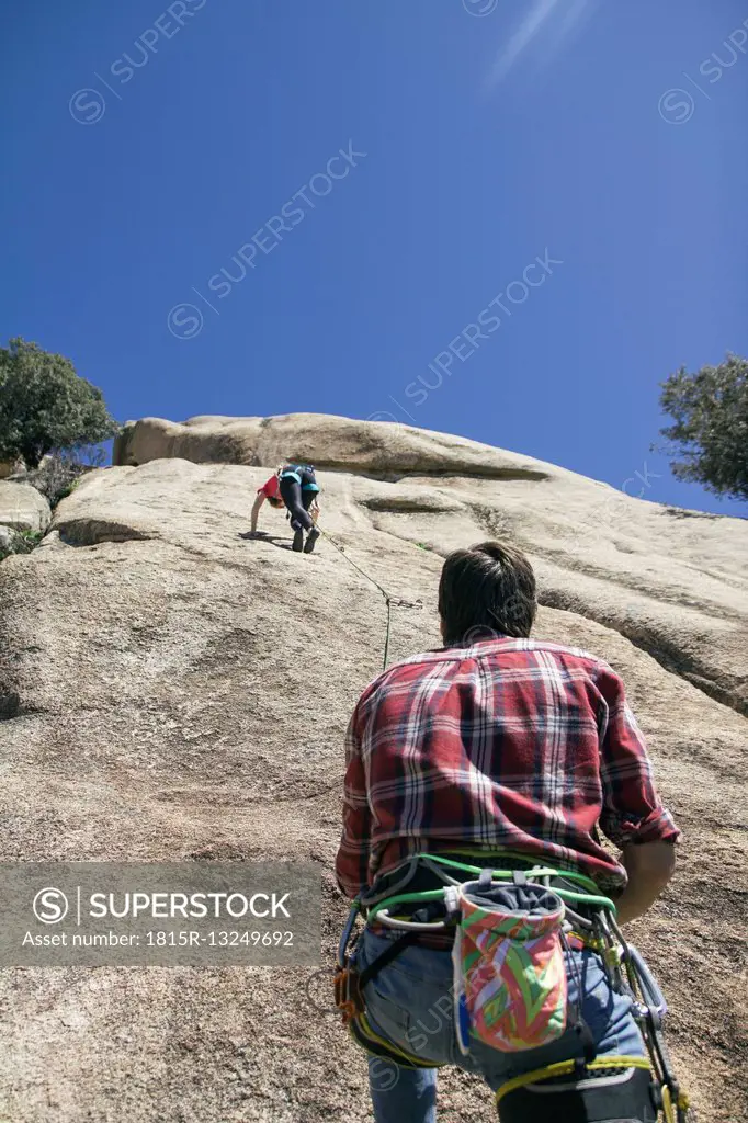 Climber securing a climber woman during climbing