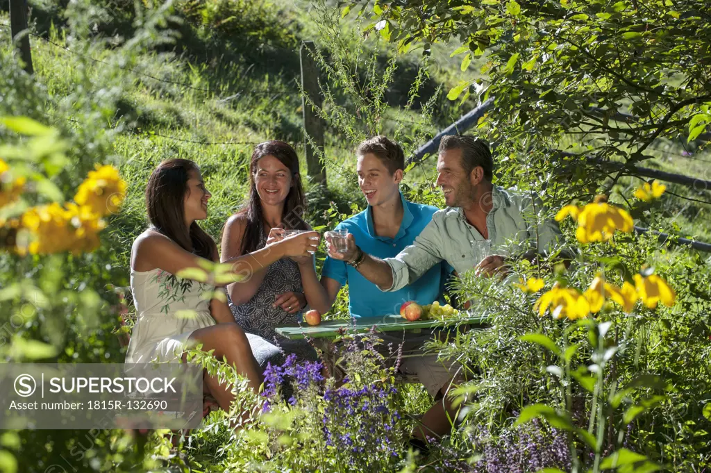 Austria, Salzburg, Family chatting in garden, smiling