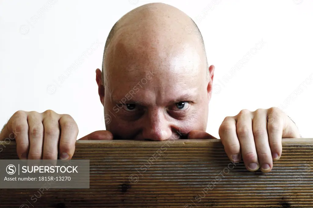 Man watching from behind board