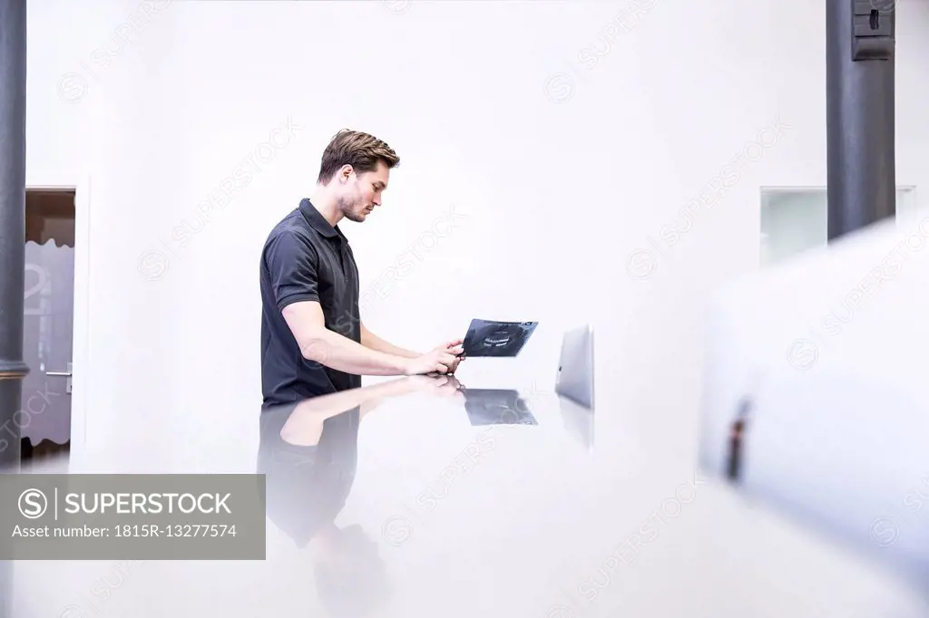 Dentist looking at x-ray image, standing at reception