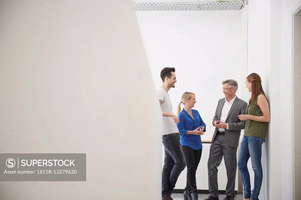 Group of business people meeting in office corridor