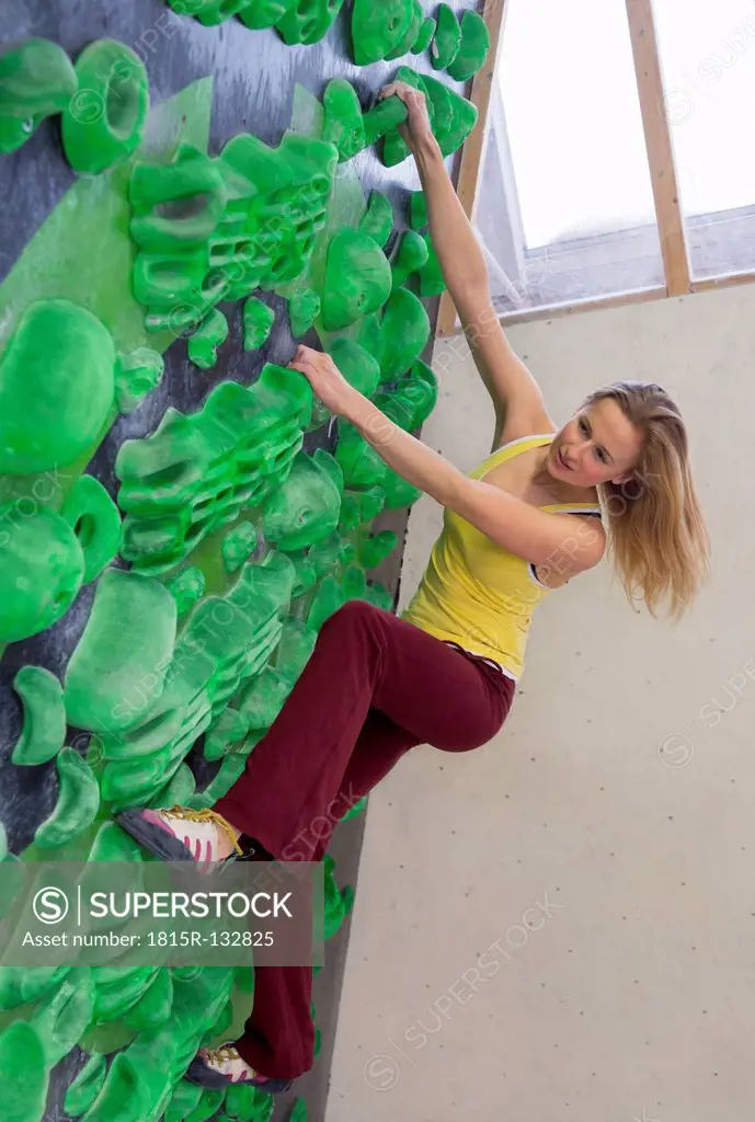 Germany, Bavaria, Munich, Young woman bouldering