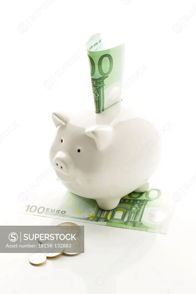 Piggy bank with euro notes and coins on white background, close up