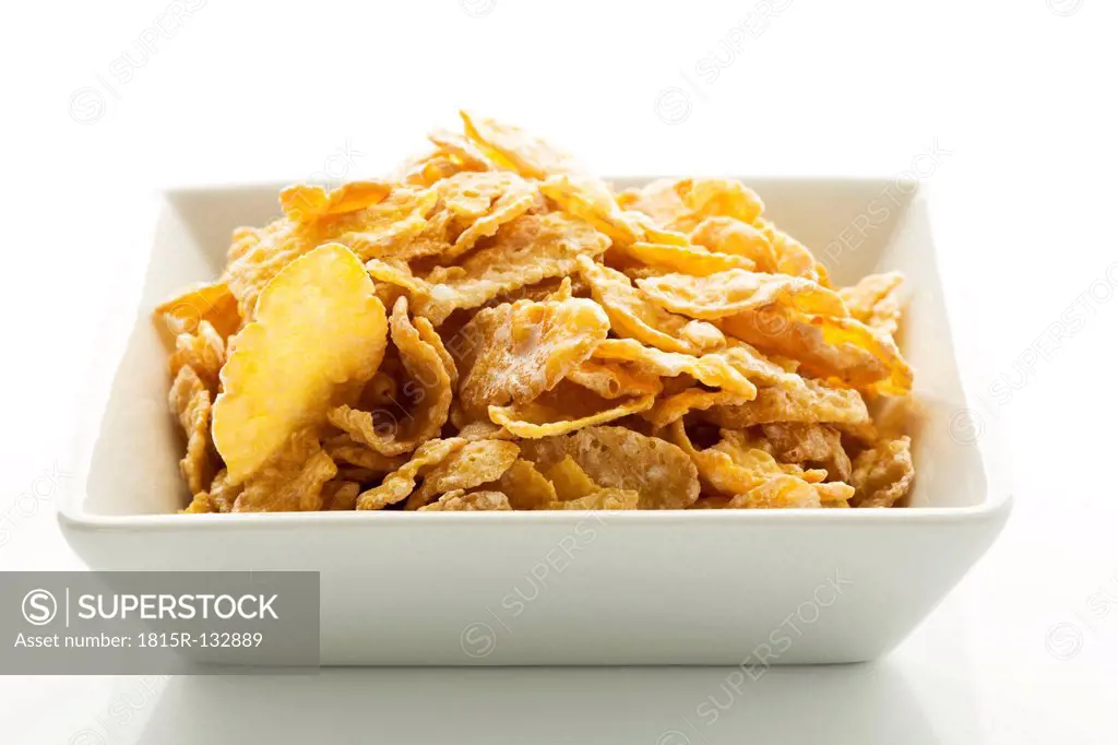 Bowl of cornflakes on white background, close up