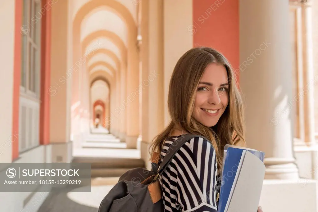 Portrait of smiling student in archway
